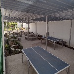 Fotografía del área de convivencia con mesas de trabajo y de ping pong junto al edificio FM5